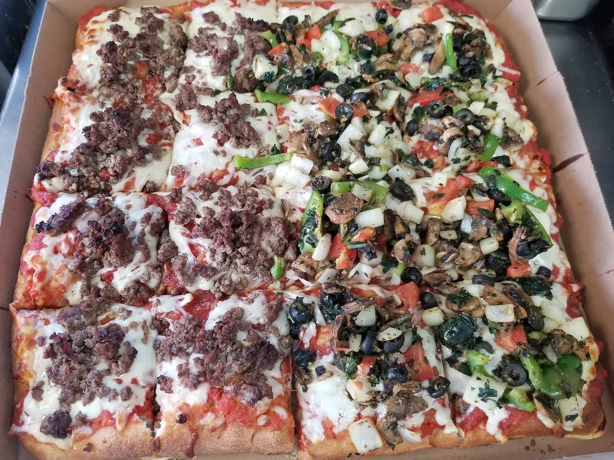 A Sicilian pie in the box, half ground beef and half vegetable