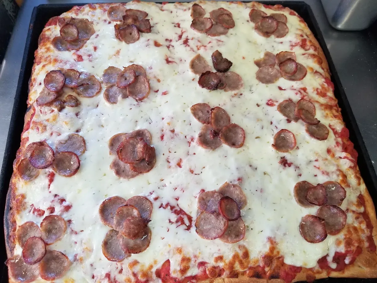 A Sicilian tray pie with clusters of pepperoni