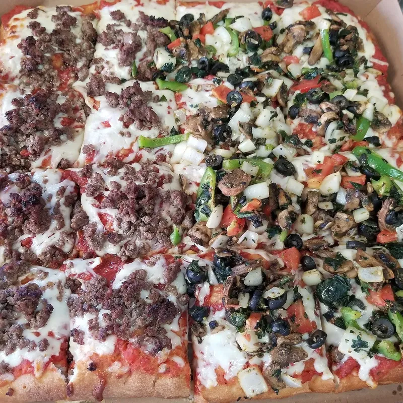 A Sicilian pie in the box, half ground beef and half vegetable