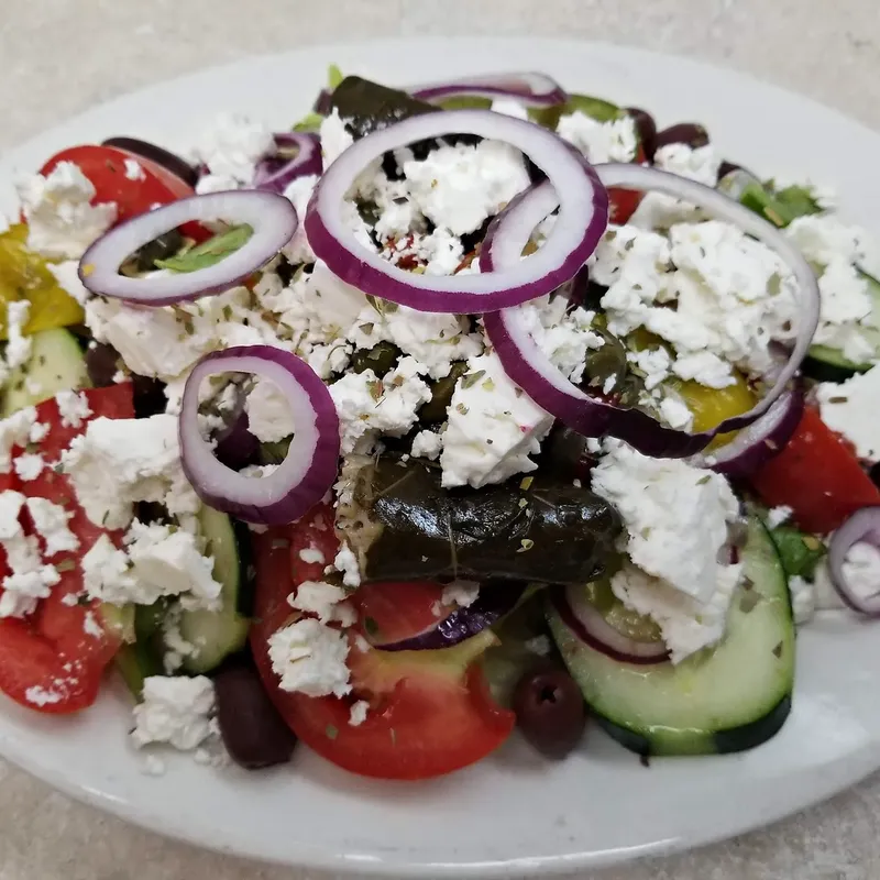 A Greek salad with feta and stuffed grape leaves