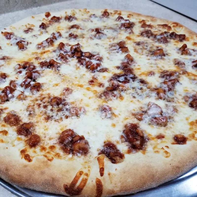 A white pizza with sausage or bacon crumbles