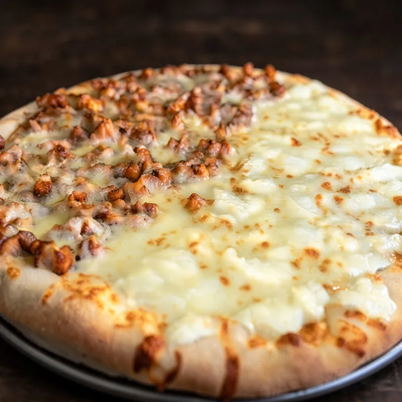 A half cheese, half sausage pizza on a silver pan