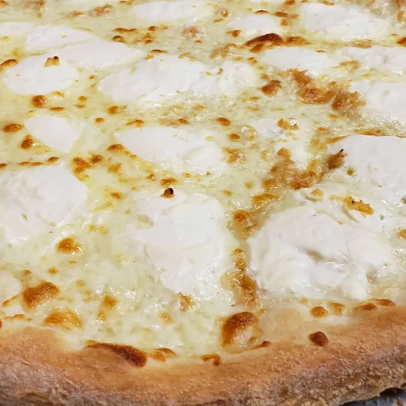 A white pizza with dollops of ricotta