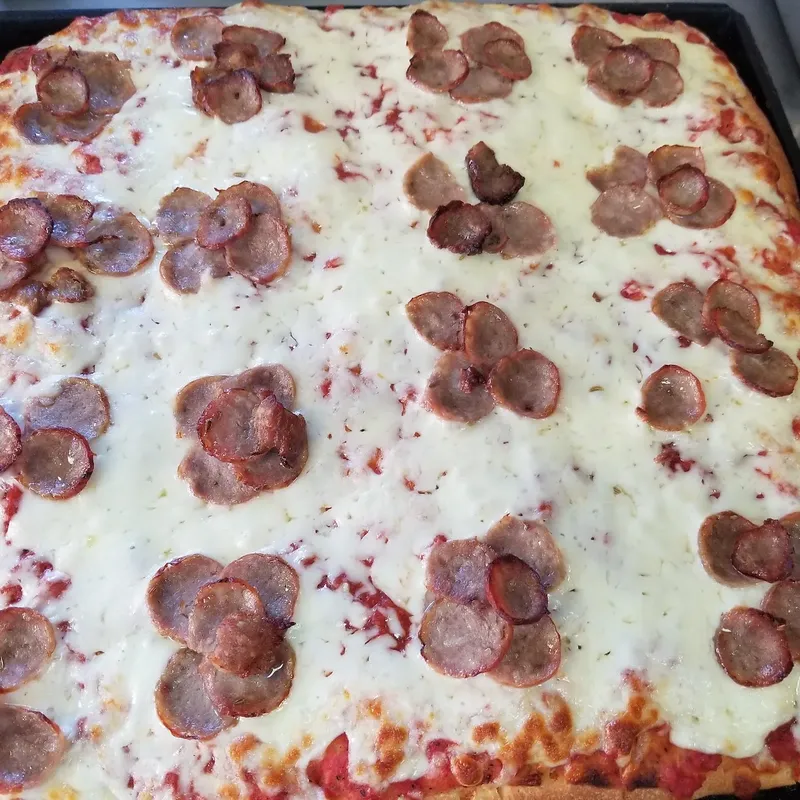 A Sicilian tray pie with clusters of pepperoni